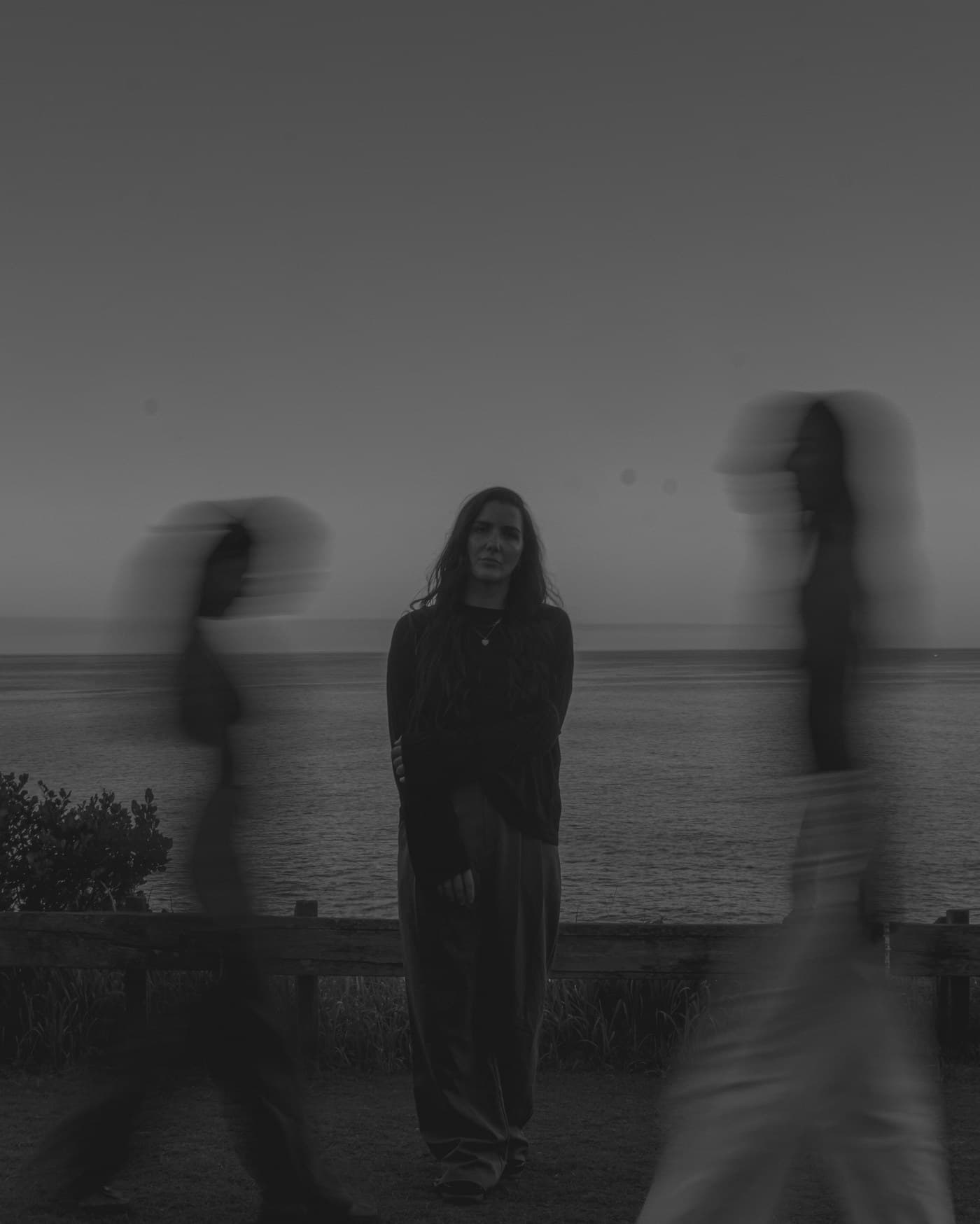 Jayde Baker by the sea at dusk, the Lokah team walking either side